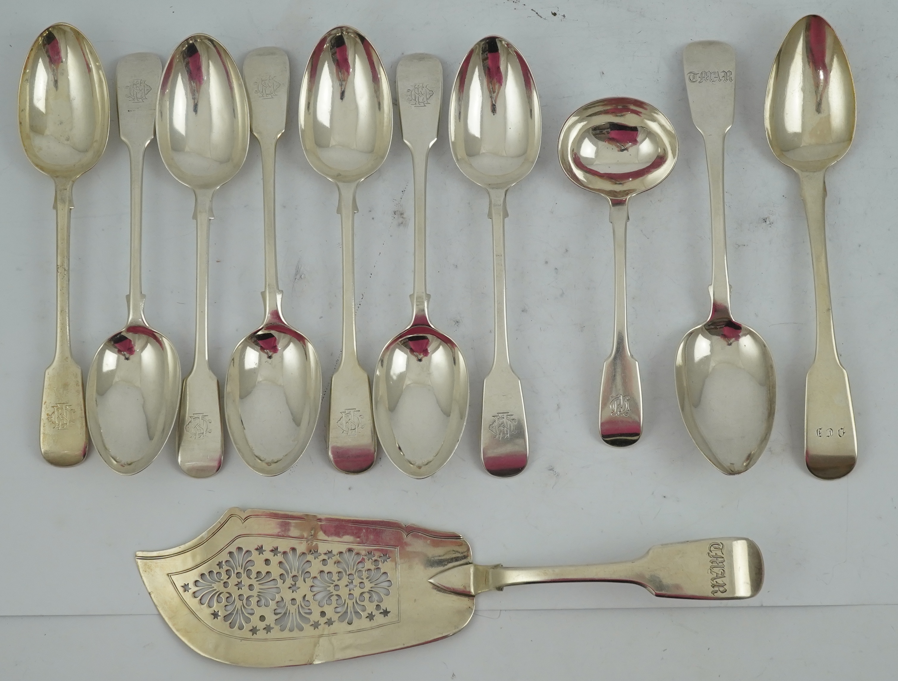 A matched set of seven late Victorian silver table spoons by Goldsmiths & Silversmiths Co Ltd (5) and Francis Higgins (2), London, 1894, together with a similar silver sauce ladle, two earlier silver table spoons and a W